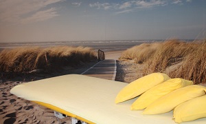 Behandlungsliege mit Strandtapete im Hintergrund